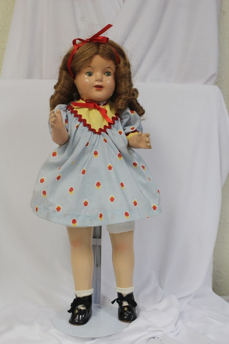 A Shirley Temple-Style Doll: possibly made by Ideal in the 1950's - shoes have been replaced - 19" tall - stand included