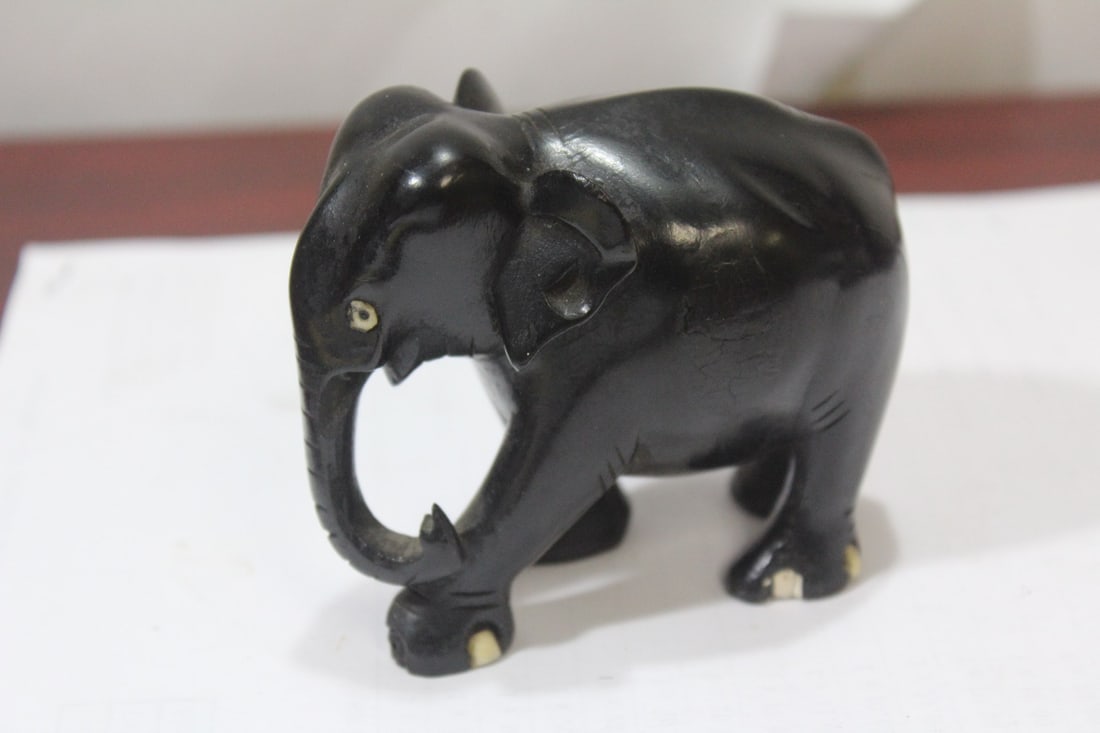 A Woden Elephant Figurine: please note: foot chips - 3 1/4" across