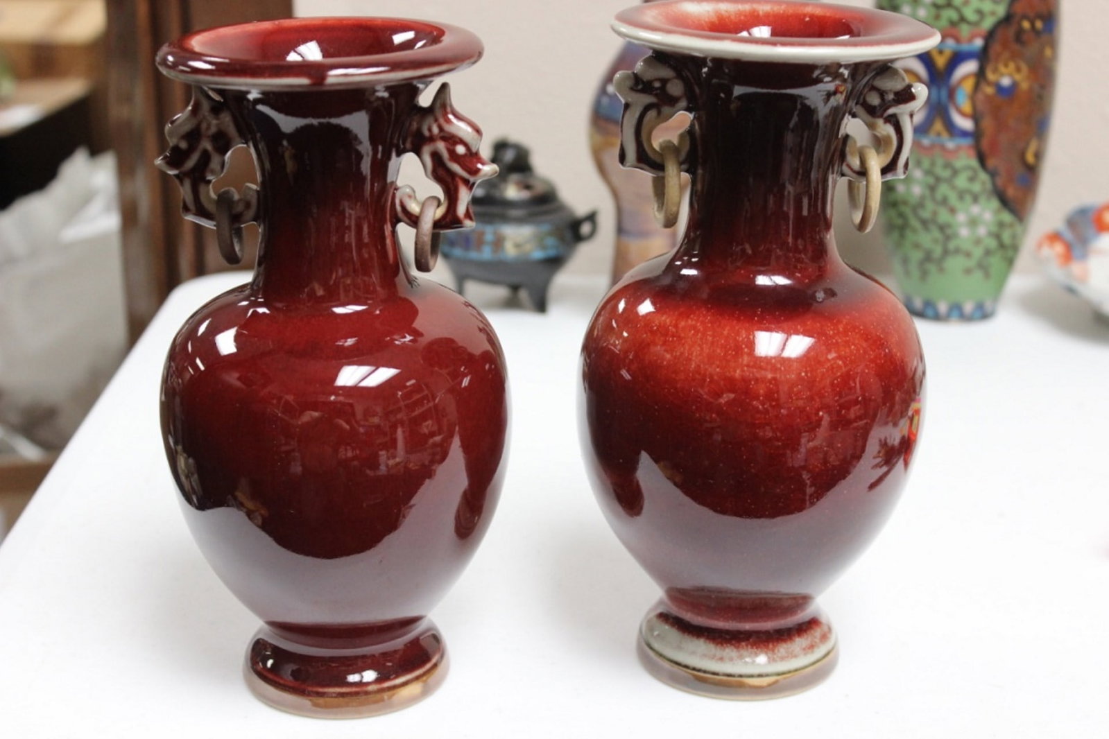 Pair of Oxblood Chinese Vases with Loose Ring: Marked on bottom. Measures 8 3/4" tall each. Circa 20th century.