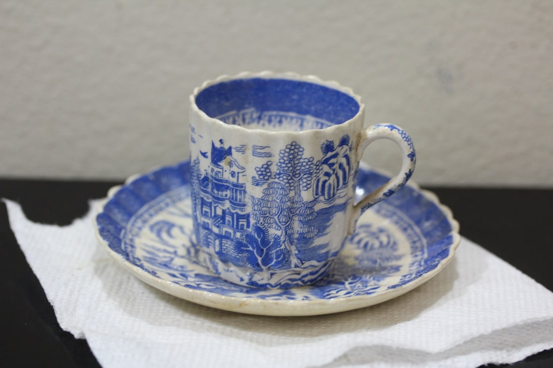 An Antique Blue and White Cup and Saucer: Oriental motif - cup= 2 1/4" tall