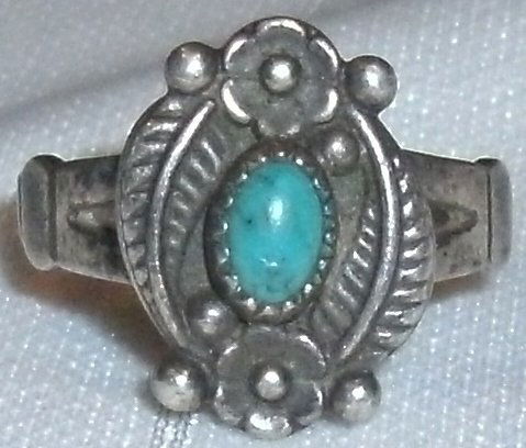 Vintage Sterling Turquoise Native American SW Ring: small sterling and turquoise, South West, Native American ring.The ring is stamped sterling with a single turquoise stone and has an embossed flower on each end, with leaves / feathers on the sides, a
