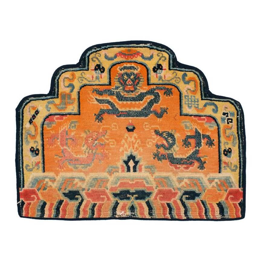 Shigatse Thigyabyo: First quarter 20th century, 57 x 73 cm, Central Asia, South Tibet A backrest cover for a lama’s throne presenting three dragons in the orange-ground field, Buddhist symbols in the yellow border, a w