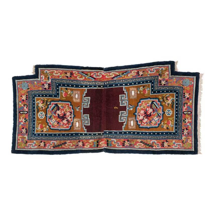 Gyantse Makden: Ca. 1900, 124 x 58 cm, Central Asia, South Tibet A saddle bottom rug composed of two trapezoid halves woven separately and joined at the centre. The light brown fields each contain a light red floral 