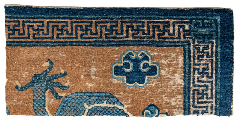 Ningxia Dragon Rug Fragment: mid 18th century, 96 x 47 cm, West China The upper right corner of a Ningxia rug woven around 1750 showing dragons and clouds in the light-brown field and a swastika meander border.