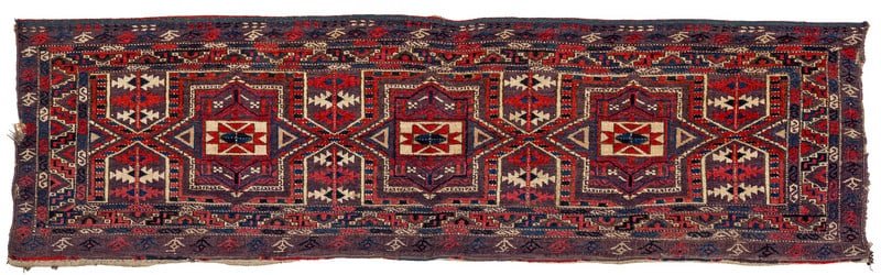 Chodor Jollar: mid 19th century, 52 x 181 cm, Central Asia, West Turkestan A wide Chodor trapping with an aubergine ground. The field shows a kejebe design of three large octagrams enclosing white rectangles with a