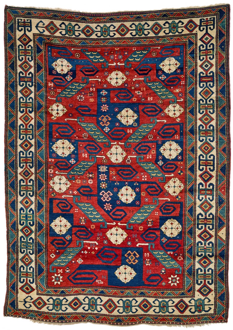 Pinwheel Kazak: mid 19th century, 247 x 179 cm, South West Caucasus The blazing red field of this Pinwheel Kazak displays two complete and seven partial representations of the steel blue rotating motifs that lend the
