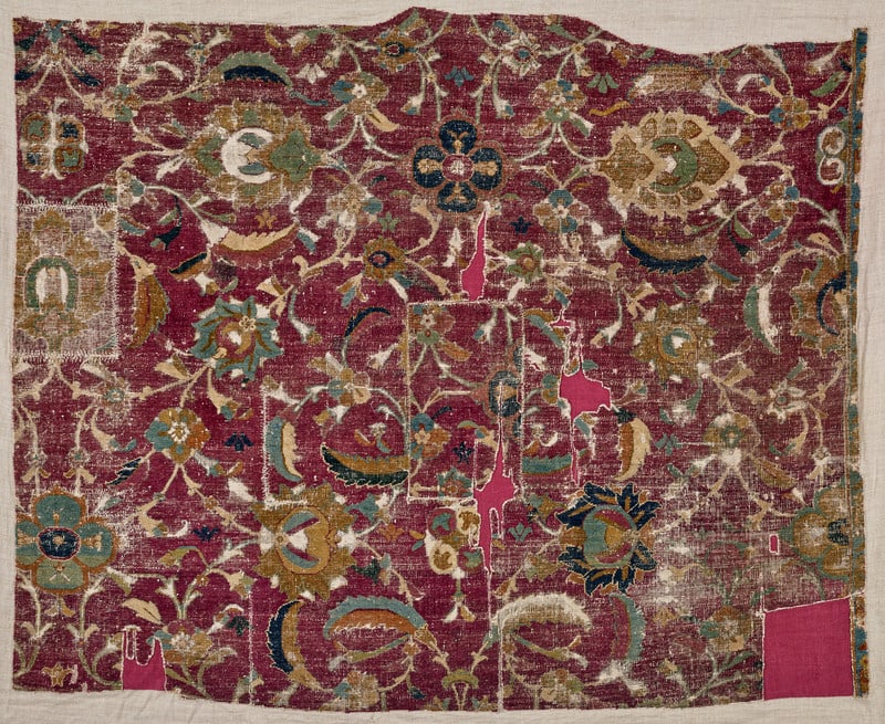 Esfahan Fragment: mid 17th century, 118 x 144 cm, Central Persia A generously sized floral repeat composed of spiralling vines which bear different palmettes, rosettes and sickle leaves covers the burgundy ground. The