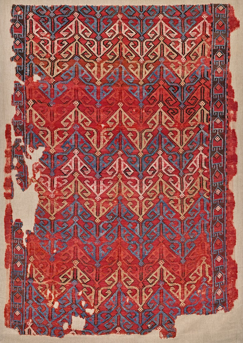 Zili Fragment: first half 19th century, 198 x 140 cm, West Anatolia In this red-ground flatweave, the powerful visual effect of the geometric design brocaded in the zili technique is an impressive feature.