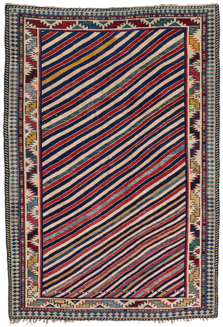 Shirvan: second half 19th century, 160 x 108 cm, East Caucasus This rare Shirvan displays a field design of slightly sinuous diagonal stripes in kaleidoscopic colours and a horizontal row of tiny crosses at