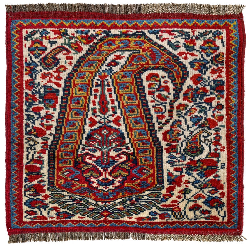 Khamseh Bag Face: late 19th century, 49 x 51 cm, South West Persia, Fars The knotted face of a Khamseh bag. The white field shows an oversized boteh among short floral stems.