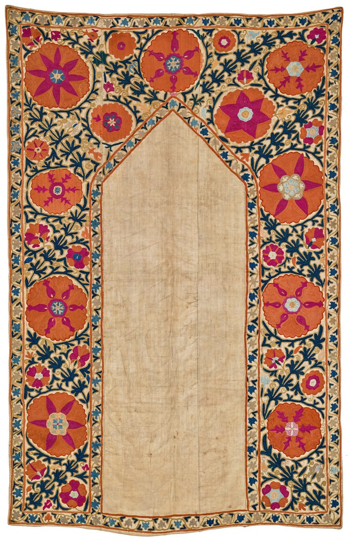 Kermina Joynamoz Suzani: mid 19th century, 153 x 99 cm, Central Asia, South West Uzbekistan A four-panel Kermina suzani largely embroidered in the yurma chain stitch. The undecorated mihrab field has a pointed arch. The main