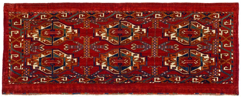 Tekke Torba: first half 19th century, 46 x 120 cm, Central Asia, West Turkestan Six unusually large primary guls and, likewise very large, chemche cruciform motifs fill most of the field of this early torba. The
