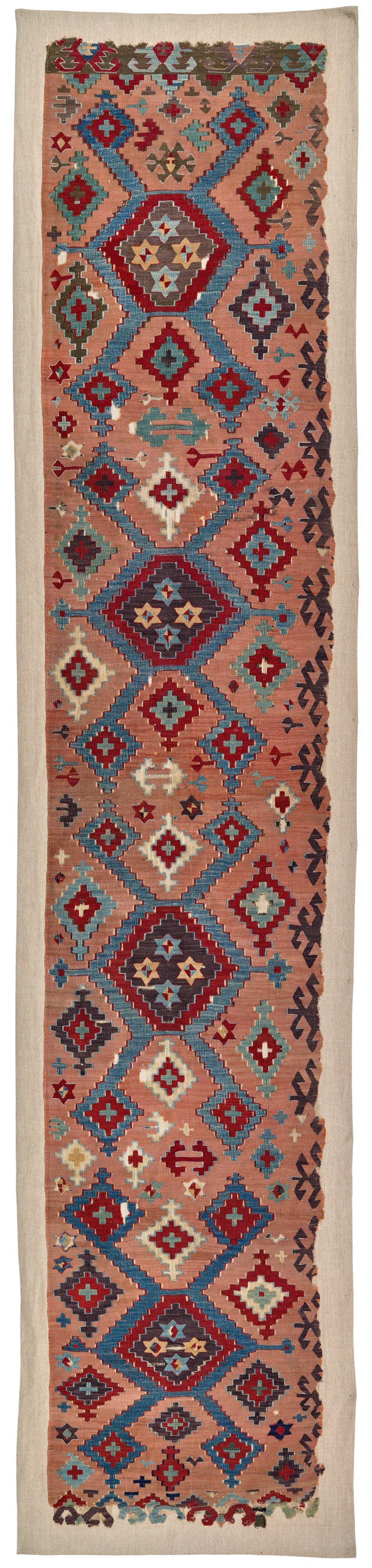 Aksaray Kilim: first half 19th century, 397 x 76 cm, Central Anatolia Half of a kilim originally composed of two panels. Four brown diamonds with an interior design of four stars are placed on an apricot ground.
