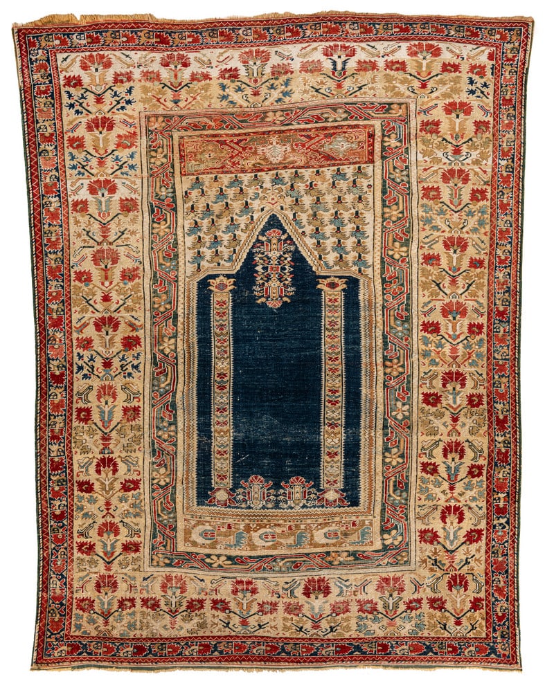 Ghiordes Prayer Rug: first half 18th century, 167 x 132 cm, West Anatolia, Manisa This classic Ghiordes prayer rug features a blue field, two columns and a pointed triangular arch. The white tympanon is filled with small 