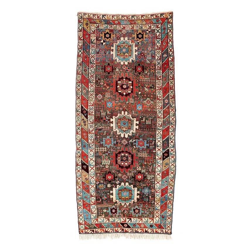 Shahsavan: Second half 19th century, 286 x 133 cm, North West Persia, Azerbaijan Five large rosettes with serrated outlines are aligned on the central axis of a grey-blue field very densely filled with floral an