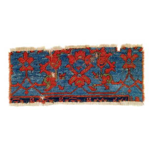 Ushak Border Fragment: 17th century, 22 x 53 cm, West Anatolia A fragment of an Ushak rug. The surviving piece constitutes a section of the mid blue main border showing red palmettes attached to thin, straight red vines. A