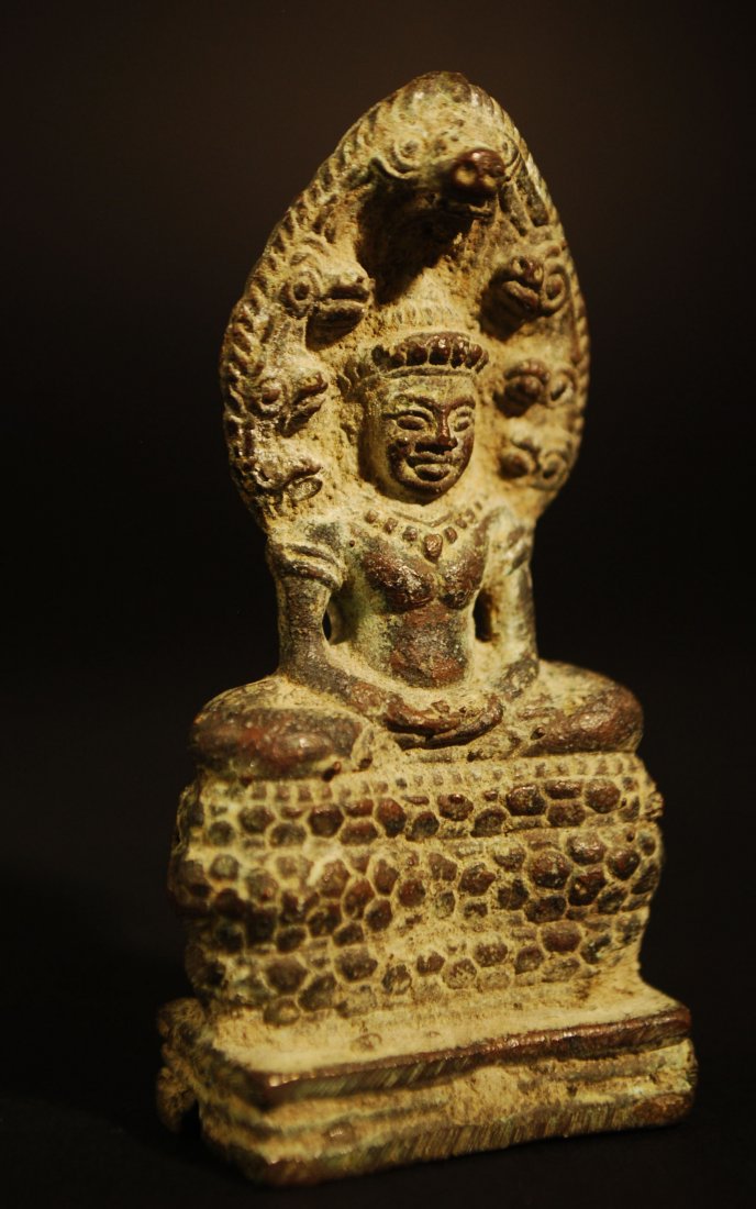 12TH CENTURY BRONZE BUDDHA UNDER NAGA: Ca. 12th Century A.D. Angkor, Cambodian Buddha sheltered by a naga. _x000B_This sculpture depicts the serpent king Muchilinda protecting the Buddha Shakyamuni from heavy rains.There are numerous extan