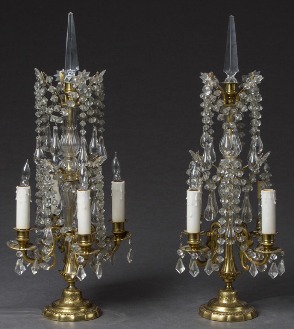 Pair of Brass and Crystal Four Light Girandole Lamps,: Pair of Brass and Crystal Four Light Girandole Lamps, 20th c., with pointed crystal spires above wire arms hung with prisms and prism chains, on glass central supports, with central wire arms, joined 