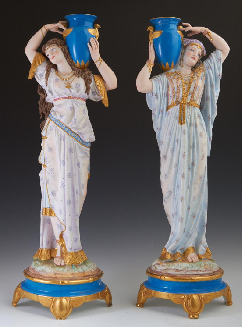 Pair of Continental Bisque and Porcelain Water: Pair of Continental Bisque and Porcelain Water Carriers, late 19th c., each maiden in a long robe with an amphora on her shoulder, with gilt and enamel decoration, the bottom of one impressed "609," H