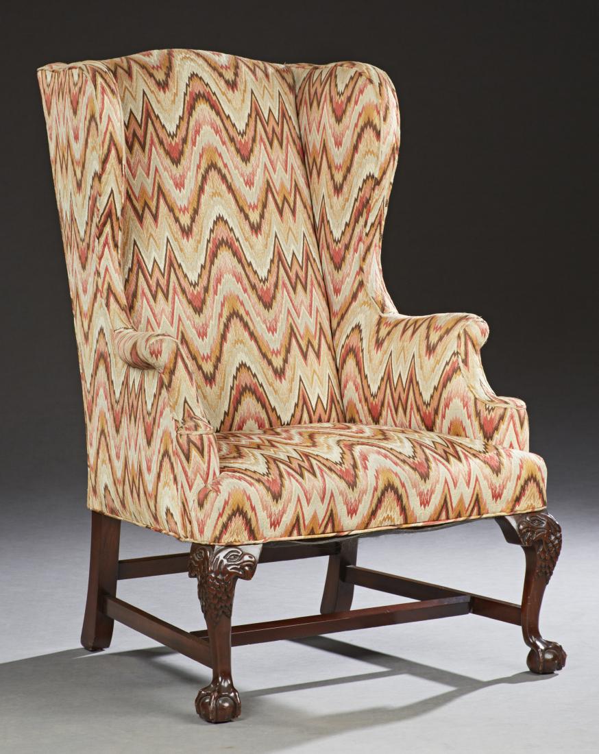 Chippendale Style Mahogany Upholstered Wingback: Chippendale Style Mahogany Upholstered Wingback Armchair, 19th c., the arched high back over a trapezoidal seat, on eagle carved legs with ball and claw feet joined by an H-form stretcher, in flame st