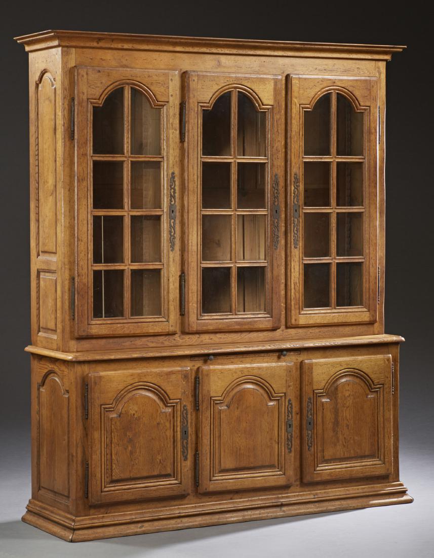 French Provincial Carved Oak Buffet a Deux Corps,: French Provincial Carved Oak Buffet a Deux Corps, 19th c., the stepped crown over three arched mullioned glazed doors with large fiche hinges and escutcheons on a base with a center pull out slide, ov