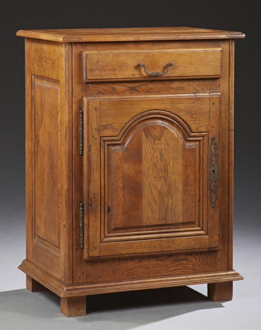 French Provincial Carved Oak Confiturier, 19th c.,: French Provincial Carved Oak Confiturier, 19th c., the rectangular top with a rounded edge above a frieze drawer over a field paneled cupboard door with fiche hinges and escutcheon, on a stepped plint