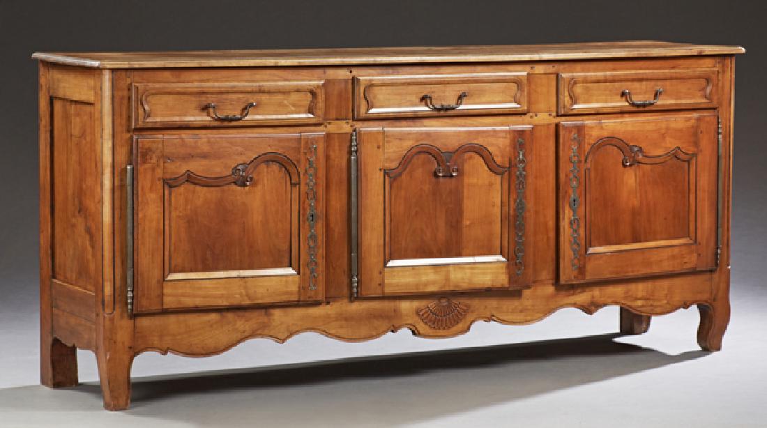 French Louis XV Style Carved Cherry Sideboard,: French Louis XV Style Carved Cherry Sideboard, 19th c., the stepped rounded corner top over three frieze drawers above three fielded panel doors with long fiche hinges and escutcheons, on cabriole leg