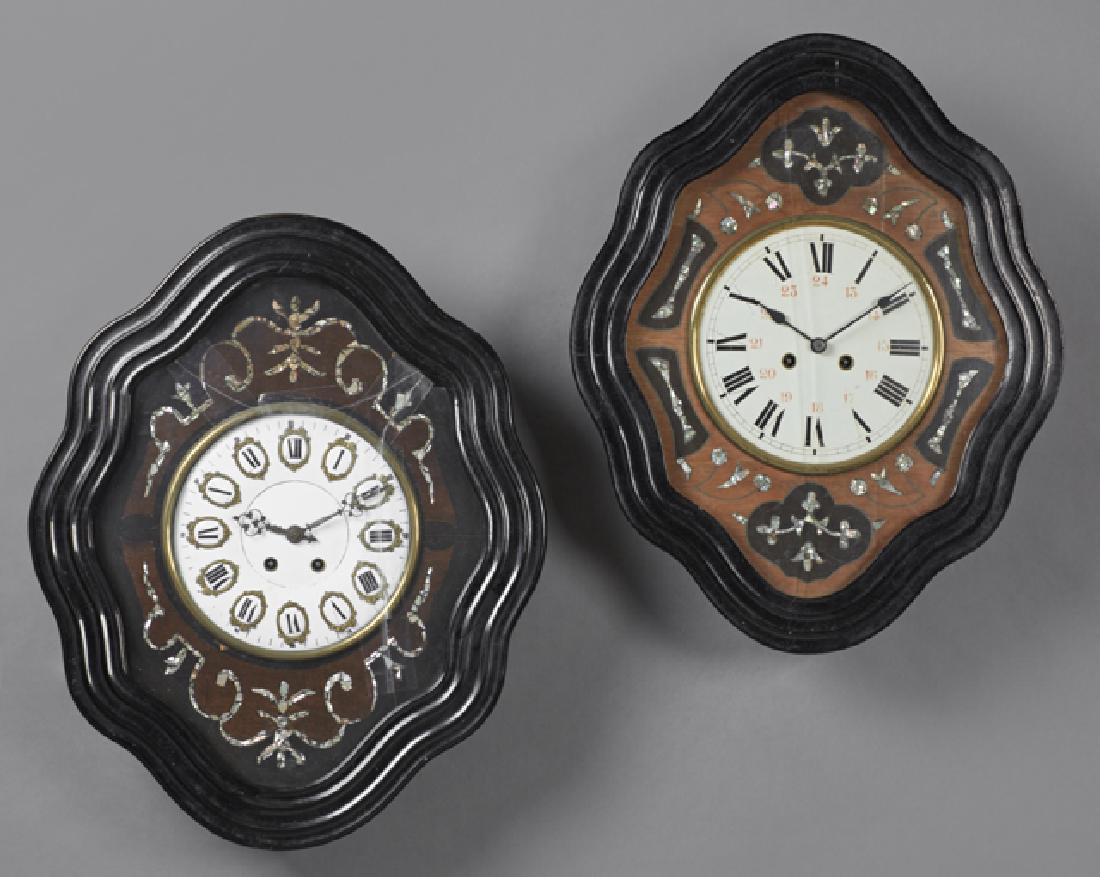 Two French Ebonized Wall Clocks, c. 1870, of: Two French Ebonized Wall Clocks, c. 1870, of reeded serpentine form, time and strike, both inlaid with mother-of-pearl, one with an enamal dial with procelain chapter marks, the larger with pendulum a