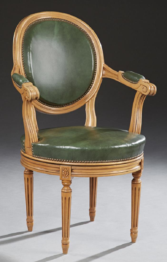 French Louis XVI Style Carved Beech Barrel Back: French Louis XVI Style Carved Beech Barrel Back Armchair, 20th c., the oval barrel back over upholstered arms and seat, on reeded tapered legs with toupie feet, in green faux leather upholstery with s