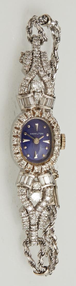 Ladyâ€™s Platinum Manual Wind Hamilton Wrist Watch, mid: Ladyâ€™s Platinum Manual Wind Hamilton Wrist Watch, mid 20th c., Ser. # 16879, with a blue face within a diamond mounted bezel, flanked by lugs with two 25 point round diamonds, 12 baguette diamo