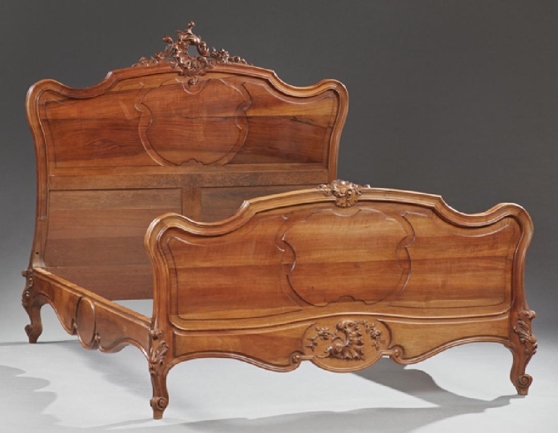 French Louis XV Style Carved Walnut Bed, 20th c., the: French Louis XV Style Carved Walnut Bed, 20th c., the serpentine headboard with a pierced leaf and C-scroll crest over a raised panel, to serpentine rails and a serpentine footboard with floral, shell