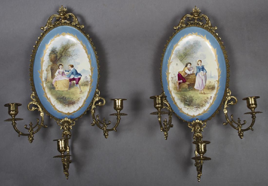 Pair of French Limoges Porcelain and Bronze Three Light: Pair of French Limoges Porcelain and Bronze Three Light Wall Sconces, early 20th c., by Bernardaud & Cie, each with a bronze relief frame issuing three scrolled candle arms, around a shallow oval Bleu