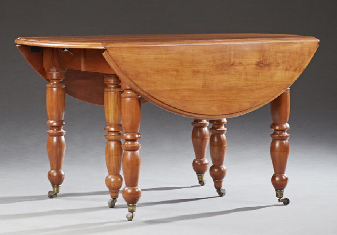 Louis Philippe Carved Cherry Drop Leaf Dining Table,: Louis Philippe Carved Cherry Drop Leaf Dining Table, 19th c., the circular top with a stepped rounded edge, on six turned and tapered legs, on ball feet on casters, H.- 28 1/2 in., Closed W.- 29 1/4 i