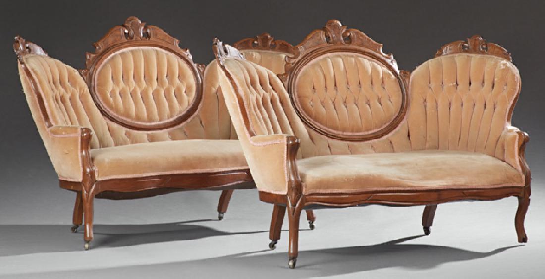 Pair of Victorian Carved Walnut Triple Back Settees,: Pair of Victorian Carved Walnut Triple Back Settees, 19th c., the serpentine crests with burled wood panels above tufted backs and arms over bowed seats with serpentine skirts, on cabriole legs with c