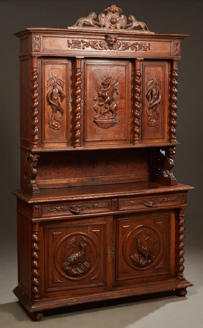 French Henri II Style Carved Oak Buffet a Deux Corps,: French Henri II Style Carved Oak Buffet a Deux Corps, c. 1880, the pierced lion and shield crest over a stepped crown above triple setback cupboard doors flanked by high relief carved doors flanked by