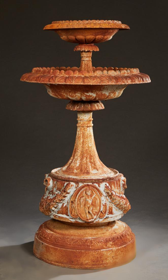 Cast Iron Two Tier Fountain, 20th c., with a lobed: Cast Iron Two Tier Fountain, 20th c., with a lobed circular bowl on a tapered fluted support to a larger like bowl on a tapered support to a base with relief bows and floral garlands, on a stepped rel