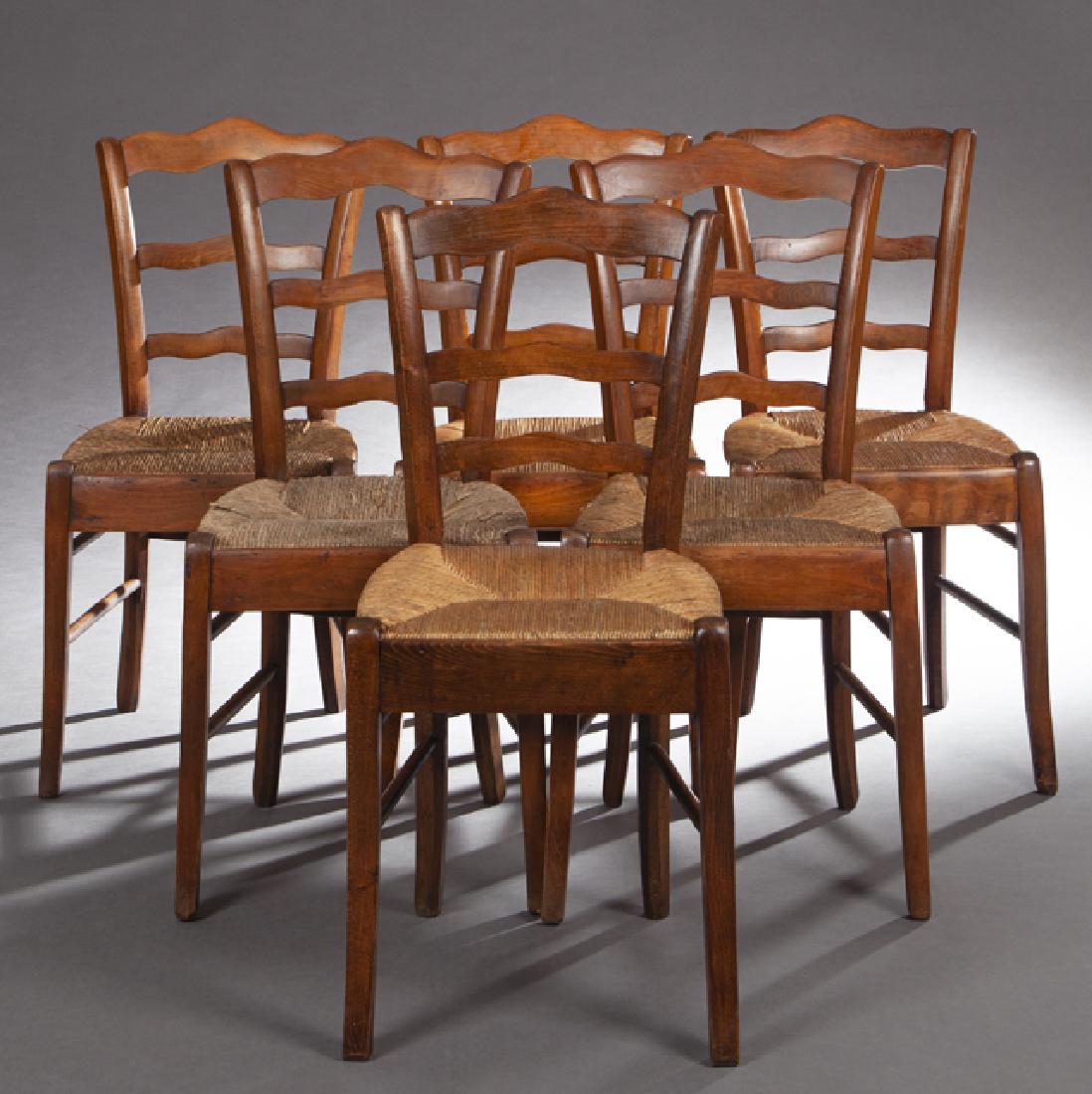 Set of Six French Provincial Carved Birch Side Chairs,: Set of Six French Provincial Carved Birch Side Chairs, late 19th c., the serpentine crest rails over matching ladder backs above trapezoidal rush seats, on splayed legs joined by stretchers, H.- 34 in