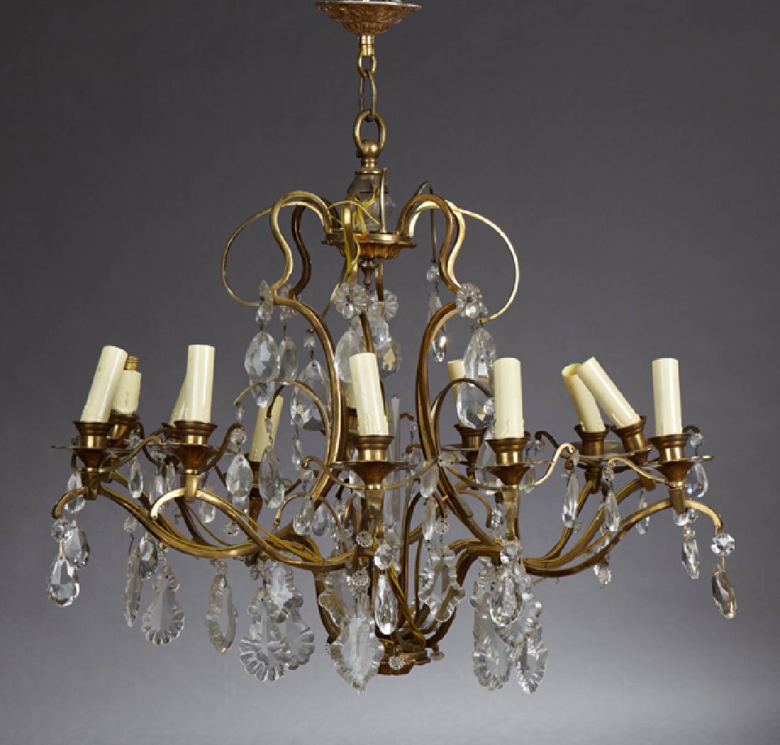 French Brass Art Deco Twelve Light Corbeille: French Brass Art Deco Twelve Light Corbeille Chandelier, c. 1930, the top with scrolled prism hung wires, over six curved arms with two lights each, hung with teardrop and pendalogue prisms, with cano