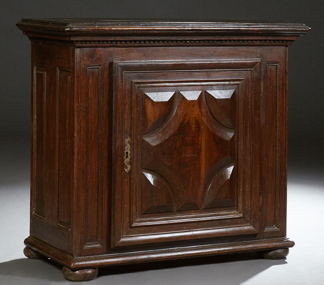 French Louis XIII Style Carved Walnut Confiturier, 19th: French Louis XIII Style Carved Walnut Confiturier, 19th c., the rounded corner stepped top above a fielded relief panel cupboard door with an iron escutcheon and fiche hings, flanked by fieled panels 