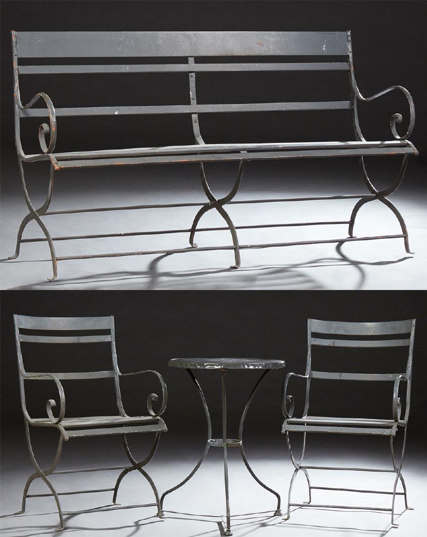 Four Piece Iron Patio Set, 19th c., consisting of a: Four Piece Iron Patio Set, 19th c., consisting of a bench, a circular table and two armchairs, each with slatted backs and seat flanked by scrolled arms, on X-form legs, Table- H.- 28 in., Dia.- 19 3/
