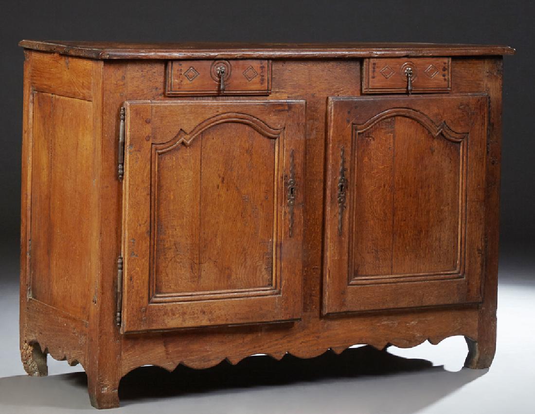 French Louis XV Style Carved Oak Sideboard, 19th c.,: French Louis XV Style Carved Oak Sideboard, 19th c., the stepped edge rectangular top above two frieze drawers over two cupboard doors with steel escutcheons and fiche hinges, on black feet joined by 
