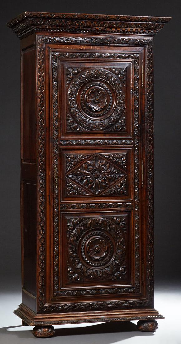French Provincial Renaissance Style Carved Oak: French Provincial Renaissance Style Carved Oak Bonnetiere, 19th c., the stepped dentil molded crown above a highly carved three panel door, on a stepped base on bun feet, H.- 80 in., W.- 35 1/2 in., D