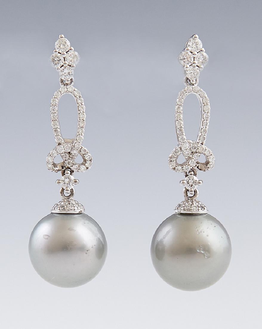 Pair of 14K White Gold Earrings, each with a diamond: Pair of 14K White Gold Earrings, each with a diamond mounted stud suspending a diamond mounted loop and a 12 mm light grey Tahitian pearl, total diamond weight- .91 cts., H.- 1 1/2 in., W.- 1/2 in., w