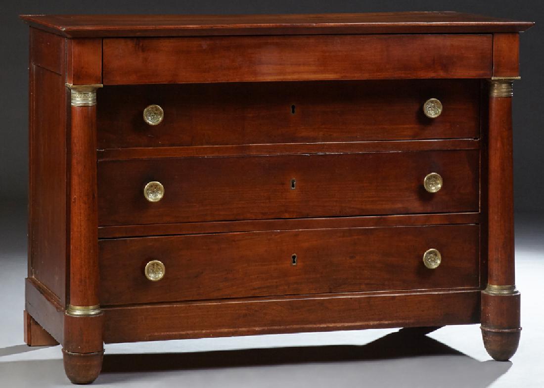 French Empire Style Ormolu Mounted Carved Cherry: French Empire Style Ormolu Mounted Carved Cherry Commode, 19th c., the rectangular top over a frieze drawer and three setback deep drawers flanked by ormolu mounted tapered columns, on tapered cylindr