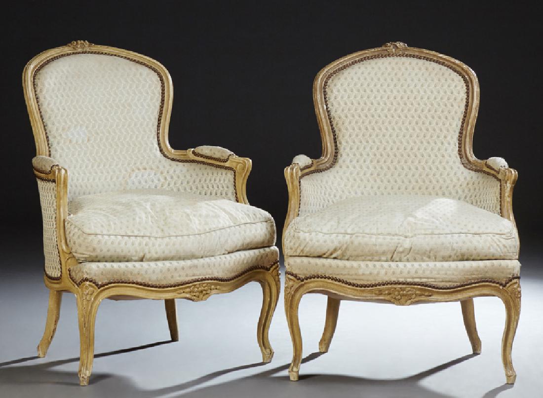 Pair of Louis XV Style Polychrome Bergeres, 20th c.,: Pair of Louis XV Style Polychrome Bergeres, 20th c., the arched crest rail above an iron tacked upholstered back to upholstered arms with curved supports flanking a loose seat cushion, on a bowed fron
