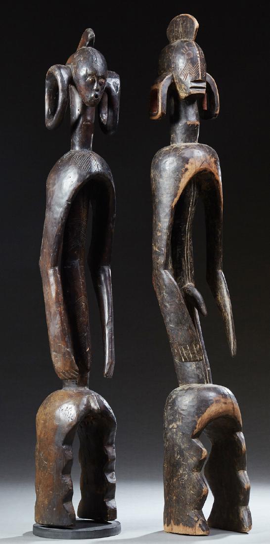 Two African Tall Carvde Wooden Figures, of a male and: Two African Tall Carved Wooden Figures, of a male and female with exaggerated earlobes, Mumaye tribe, Nigeria, Male- H.- 49 in., W.- 7 in., D.- 6 1/2 in. (2 Pcs.)