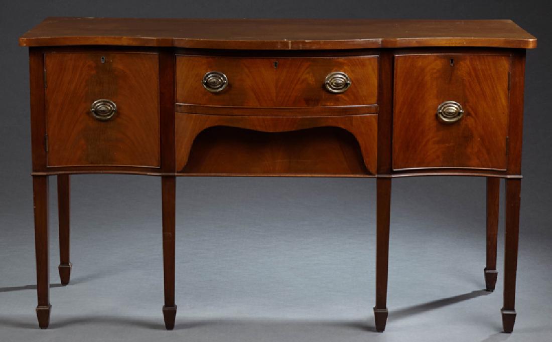 English Carved Mahogany Hepplewhite Style Sideboard,: English Carved Mahogany Hepplewhite Style Sideboard, early 20th c., the serpentine top over a bowed frieze drawer over a lower "secret" drawer, flanked by concave door cupboards, on tapered square leg