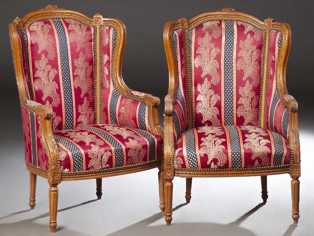 Pair of Louis XVI Style Carved Beech Wing Chairs, 20th: Pair of Louis XVI Style Carved Beech Wing Chairs, 20th c., the arched curved upholstered back over scrolled upholstered arms, to a bowed seat, on turned tapered fluted legs, in striped and floral upho