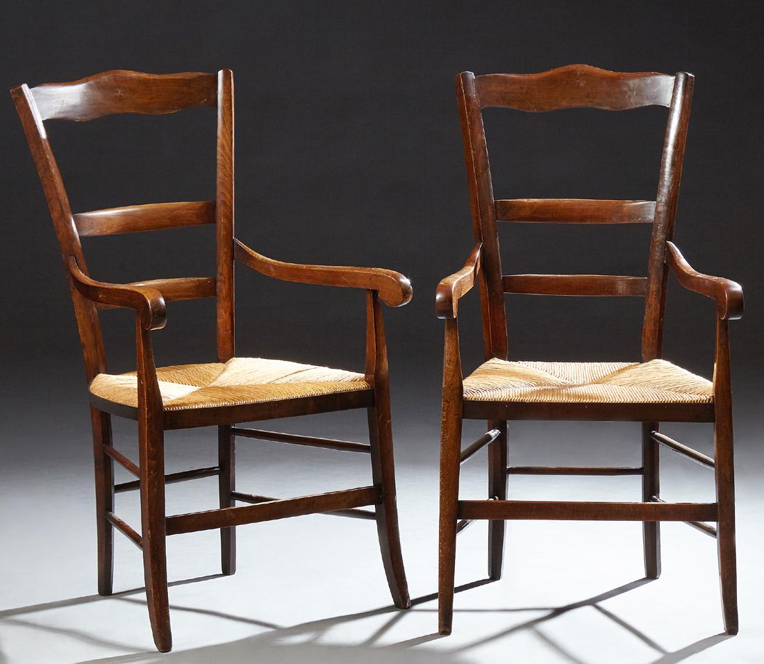 Pair of French Provincial Carved Beech Rushseat: Pair of French Provincial Carved Beech Rushseat Armchairs, 20th c., the canted ladder backs over scrolled arms and a rushseat, on saber legs joined by a box stretcher, H.- 42 in., W.- 23 in., D.- 27 i