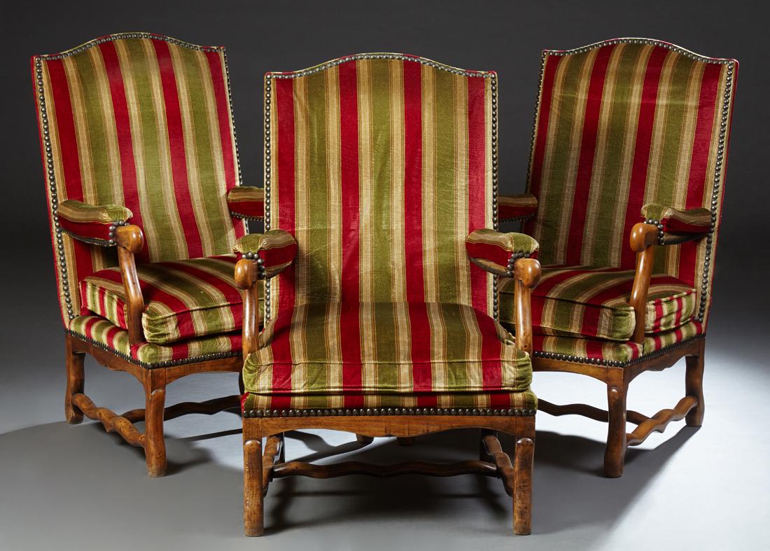 Set of Three Louis XIII Style Carved Beech Upholstered: Set of Three Louis XIII Style Carved Beech Upholstered Fauteuils, early 20th c., the canted arched high backs to upholstered arms over a cushioned seat, on cabriole legs joined by serpentine stretcher